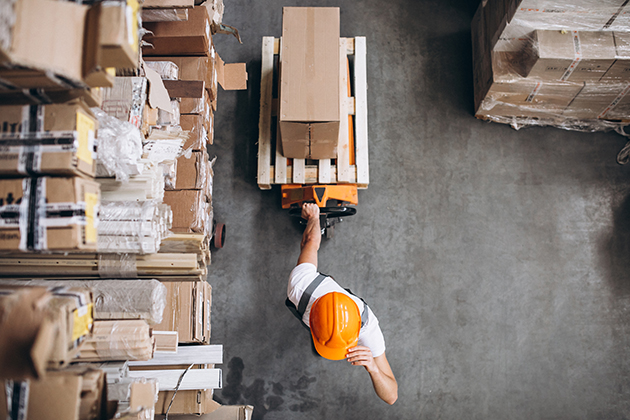 Overhead view of warehouse worker moving boxes with an electric pallet jack